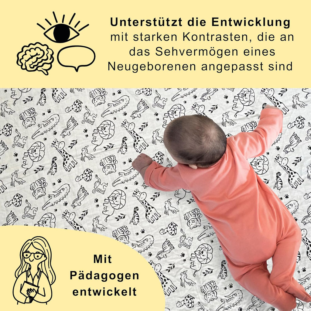 Ein Baby in einem rosa Strampler liegt ausgestreckt auf einem weißen Pucktuch mit schwarz gezeichneten Tiermotiven. Oberhalb steht der Text: ‚Unterstützt die Entwicklung mit starken Kontrasten, die an das Sehvermögen eines Neugeborenen angepasst sind‘. Unten links eine Illustration einer Pädagogin mit dem Text: ‚Mit Pädagogen entwickelt‘.